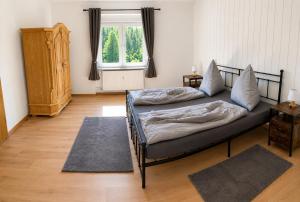 a bedroom with two beds and a window at Ferienwohnung Ernzerhof in Idar-Oberstein +36 photos