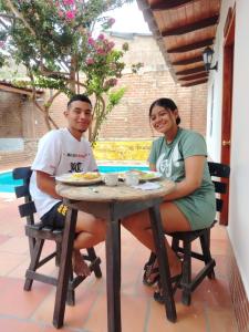 a man and woman sitting at a table with food at Casalajud Wellness in Taganga +14 photos