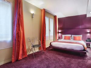 una camera con un letto e una sedia di Hôtel de Notre-Dame a Parigi
