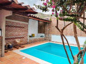 a swimming pool in a backyard with a brick house at Casalajud Wellness in Taganga