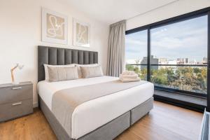 a bedroom with a large bed and a large window at Live Belgrano Boutique Apartments in Buenos Aires +16 photos