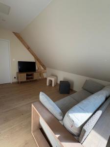 a bedroom with a large bed and a tv at La Parenthèse in Le Plouy