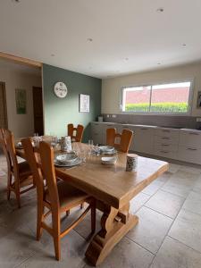 a dining room with a wooden table and chairs at La Parenthèse in Le Plouy