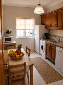 a kitchen with a table with a bowl of fruit on it at Apartamento Sunrise in Altura