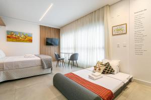 a hotel room with two beds and a table at Modern Studio | Pool | Gym #SG10 in Florianópolis