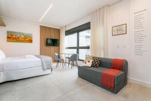 a bedroom with a bed and a couch and a table at Modern Studio | Pool | Gym #SG10 in Florianópolis