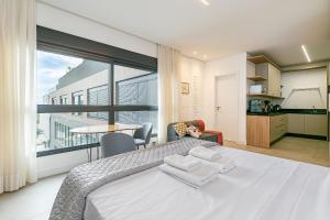a bedroom with a bed and a large window at Modern Studio | Pool | Gym #SG10 in Florianópolis +27 photos