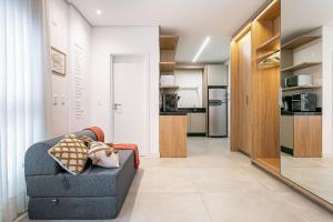a living room with a couch and a kitchen at Modern Studio | Pool | Gym #SG10 in Florianópolis