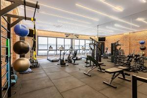 a gym with several treadmills and exercise bikes at Modern Studio | Pool | Gym #SG10 in Florianópolis