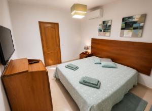 a bedroom with a bed with two towels on it at Apartamento Sunrise in Altura
