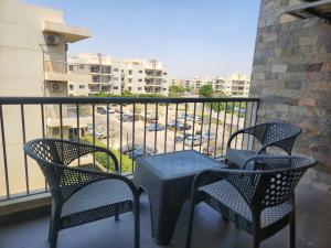 a balcony with three chairs and a table on a balcony at Modern 3-BR gated Sheikh Zayed Compound Open Views in Sheikh Zayed