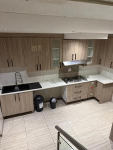 a large kitchen with wooden cabinets and a sink at Be my guest in Roodepoort +26 photos