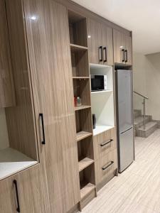 a kitchen with wooden cabinets and a refrigerator at Be my guest in Roodepoort