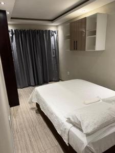 a bedroom with a white bed and a mirror at Be my guest in Roodepoort