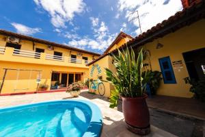 a swimming pool in a yard next to a house at Pousada Costa do Mar in Luis Correia