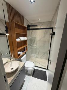 a bathroom with a shower and a toilet and a sink at Flat mobiliado no CITY HOUSE in Barreiras +10 photos