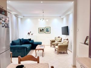 a living room with a blue couch and chairs at Krithia Apartment with Garden Family Apartment in Krithiá