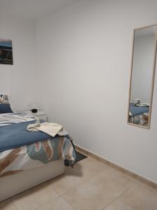 a bedroom with a bed and a mirror at ATICO ACOGEDOR LA LAGUNa in Las Lagunas