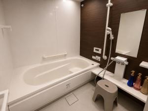 a bathroom with a white tub and a toilet at House Villa Koharu in Asahikawa +18 photos