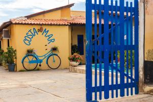 a blue gate in front of a building with a blue bike at Pousada Costa do Mar in Luis Correia