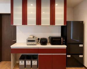 a kitchen with a black refrigerator and a microwave at House Villa Koharu in Asahikawa