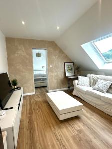 a living room with a white couch and a skylight at Bel appartement sous combles in Argelès-Gazost