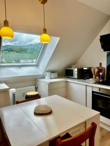 a kitchen with a table and a window at Bel appartement sous combles in Argelès-Gazost