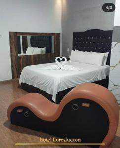 a bedroom with a large bed with a wooden headboard at HOTEL FLORES LUCXON, ca in Caracas