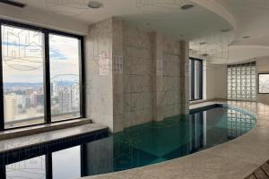 a swimming pool with a view of a city at Flat Guarulhos - 3 in Guarulhos