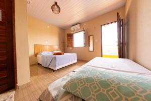 a bedroom with two beds and a window at Pousada Costa do Mar in Luis Correia +19 photos