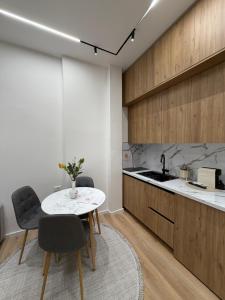 a kitchen with a table and chairs and a sink at Paris and Eneas Studios in Vlorë