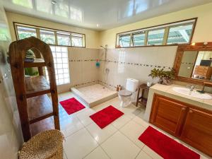 a bathroom with a shower and a sink and a toilet at Fare Faaroa Lodge in Taputapuapea