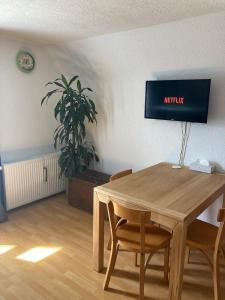 a dining room with a wooden table and a plant at RoDo Balcony - 2 Zimmer Apartment mit 1 Schlafzimmer & Balkon in Kirchheim unter Teck