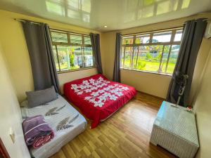 a small room with a bed and a window at Fare Faaroa Lodge in Taputapuapea