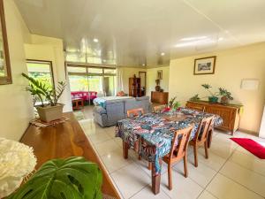 a living room with a table and a couch at Fare Faaroa Lodge in Taputapuapea +29 photos