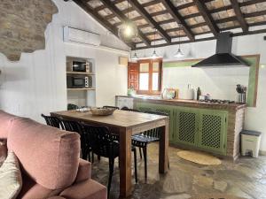 a kitchen with a wooden table and chairs in a room at La casa vieja de Marchenilla in Jimena de la Frontera