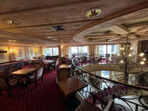 a restaurant with tables and chairs and a staircase at Kronenlodge in Seefeld in Tirol