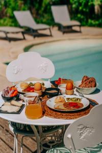 a table with food and eggs on it next to a pool at Maison Forenea chambres d'hôtes dans les bois avec petits déjeuners BIO in Sainte-Nathalène