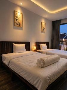 two beds in a hotel room with a window at Bareka Hotel in Phú Quốc +20 photos