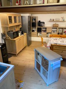 a room with a kitchen with a table and a refrigerator at Baita Bea&Benny in Carona