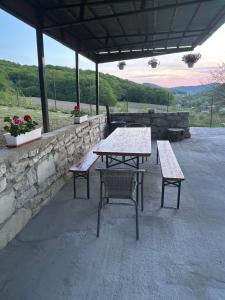 a picnic table and two benches under a pavilion at Cabana Icas in Dej