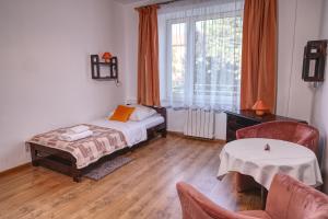 ein Schlafzimmer mit einem Bett, einem Tisch und Stühlen in der Unterkunft Hotel Monttis in Sucha Beskidzka + 51 Fotos