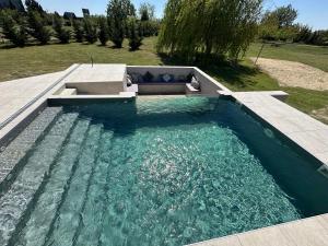 a pool of water with a bench in a yard at Reginahouse in Szigetszentmiklós