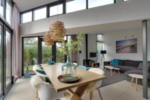 a living room with a table with a vase of flowers at Knookborst in Hollum
