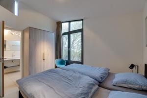 a bedroom with a bed and a window at Knookborst in Hollum