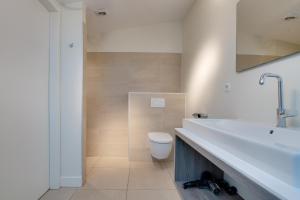 a bathroom with a white sink and a toilet at Knookborst in Hollum +13 photos