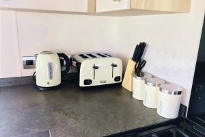 a kitchen counter with two toaster and cups on it at Spacious Caravan - Durdle Door Holiday Park in West Lulworth