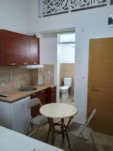 a kitchen with a table and a sink and a toilet at APARTMANSKI SMEŠTAJ SOLARIS kod Aqua Parka STUDIO APARTMANI in Soko Banja