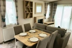 a dining room with a table and a couch at Spacious Caravan - Durdle Door Holiday Park in West Lulworth
