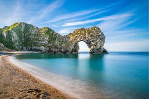 a view of a beach with an arch in the water at Spacious Caravan - Durdle Door Holiday Park in West Lulworth